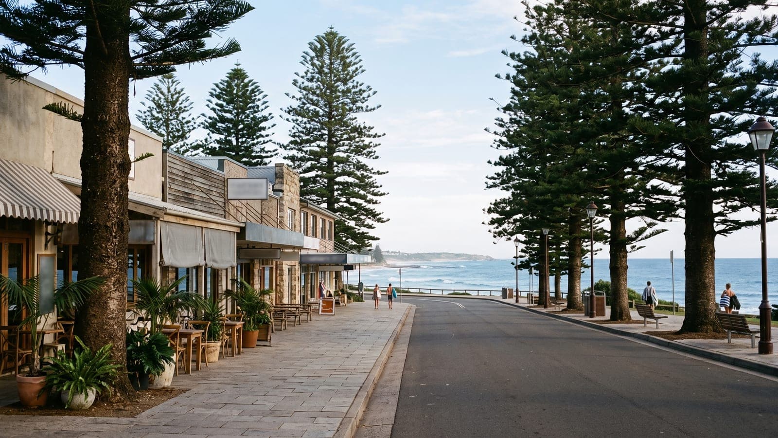 Beachside street with cafes and Norfolk pines and the ocean in the distance