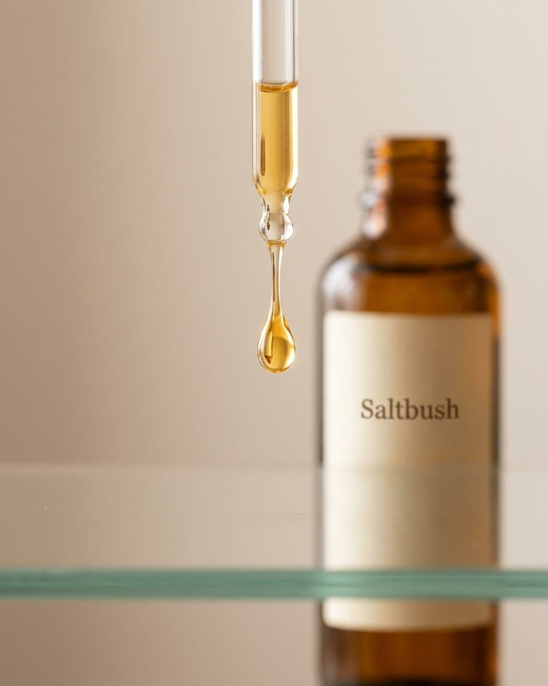 Close-up of a single golden drop of serum on clean glass